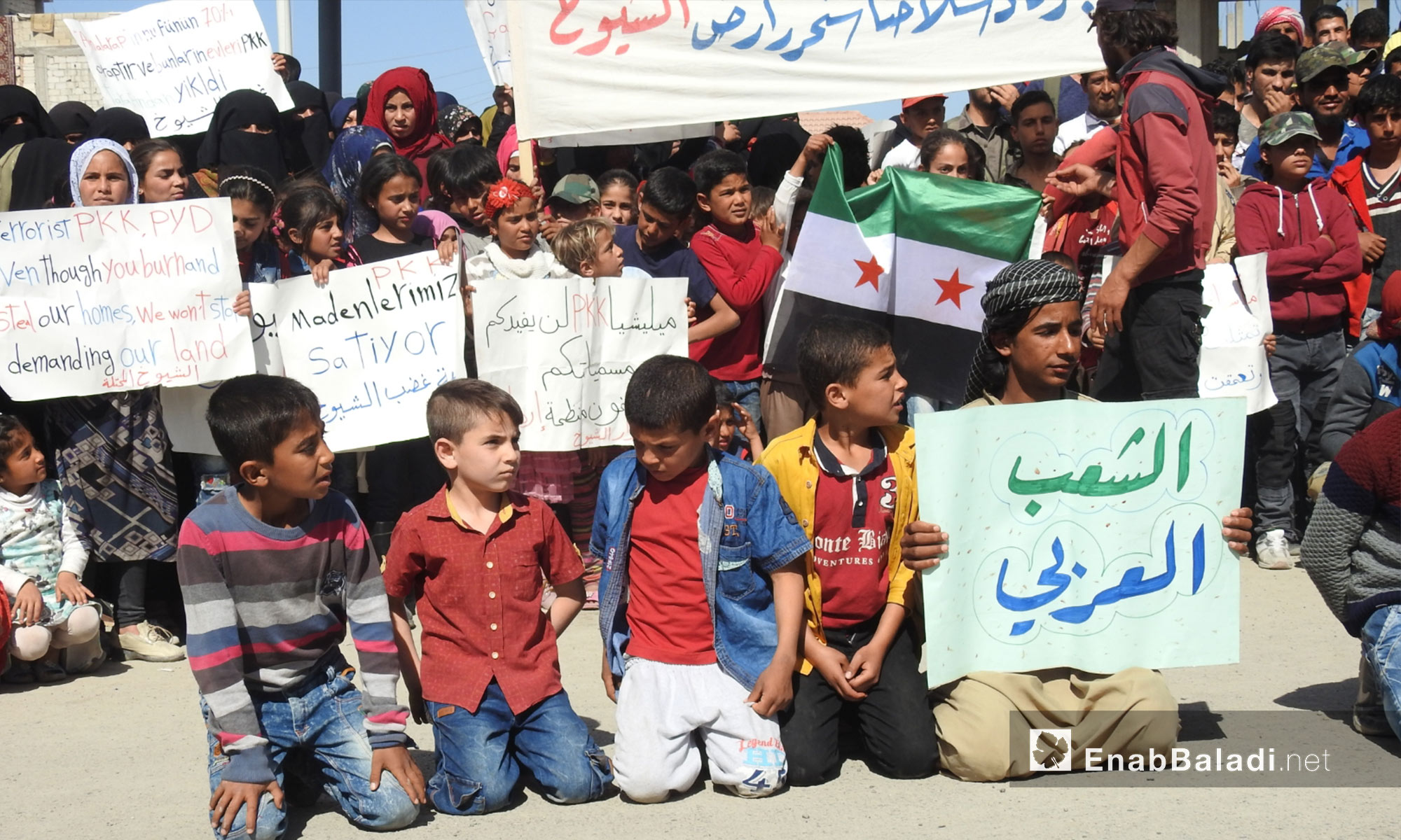 أطفال ومتظاهرون يرفعون لافتات خلال مظاهرات في جرابلس التحرك نحو شرق الفرات - 6 من نيسان 2018 (عنب بلدي)
